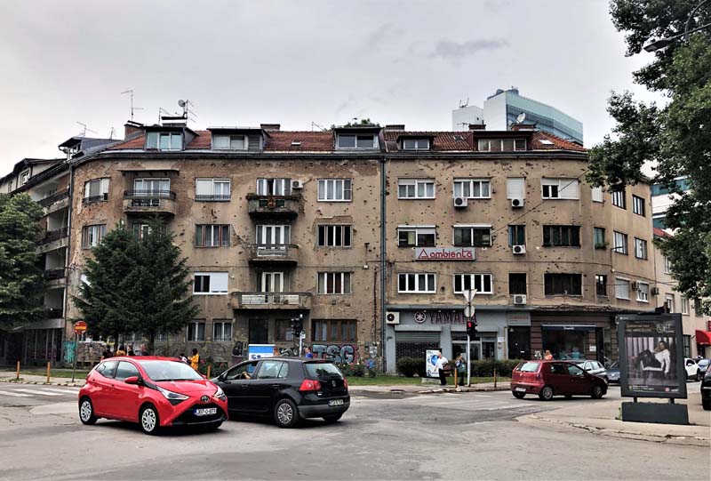 concrete building with cars parked in front