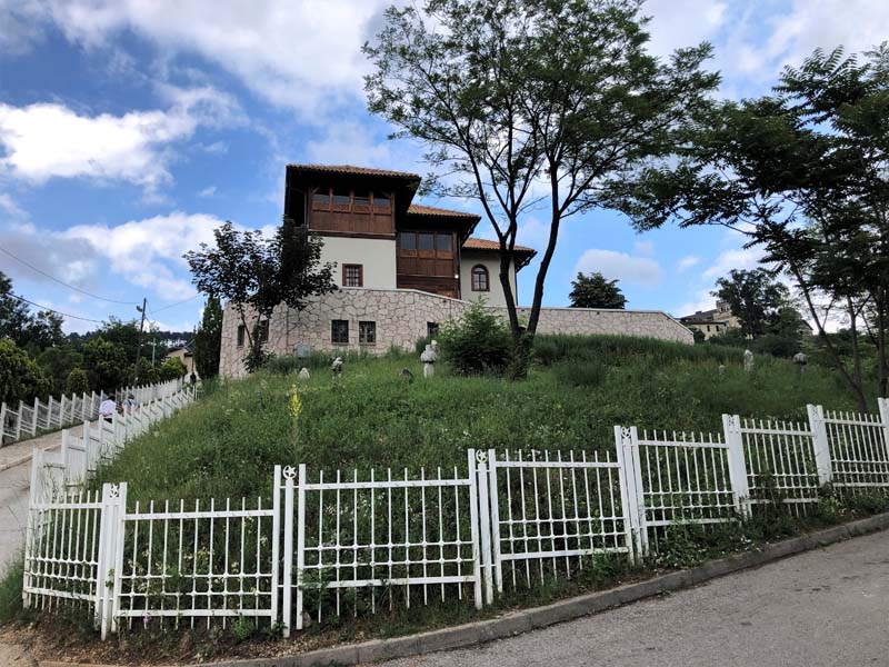 building on hill surrounded by white fencing