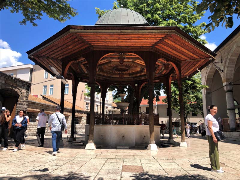 people walking around covered fountain