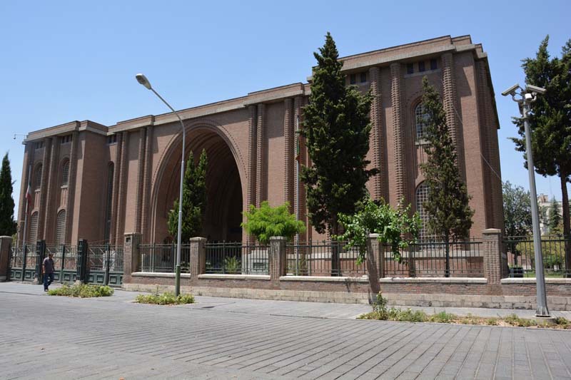 A two-story symmetrical masonry building wings with arched windows on either side of a large central arch 