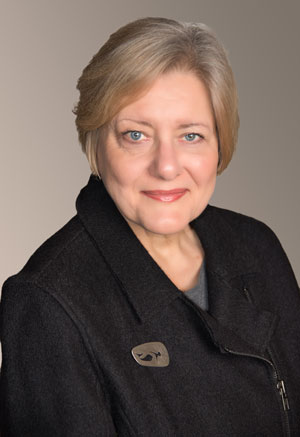 Pauline Saliga, a woman with short blond hair, wears a black jacket with brooch