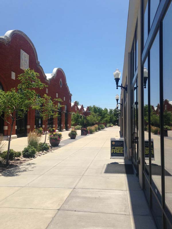 concrete walkway with buildings on either side