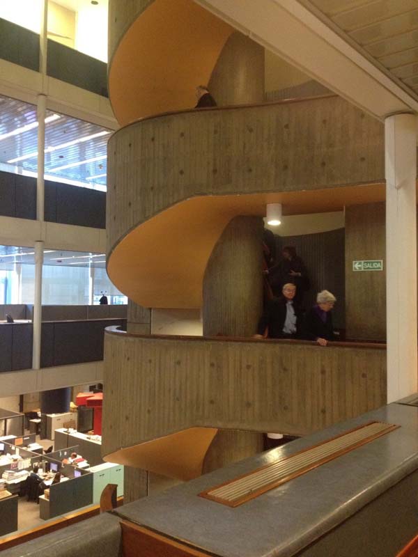 spiral concrete stairwell overlooking atrium with offices below