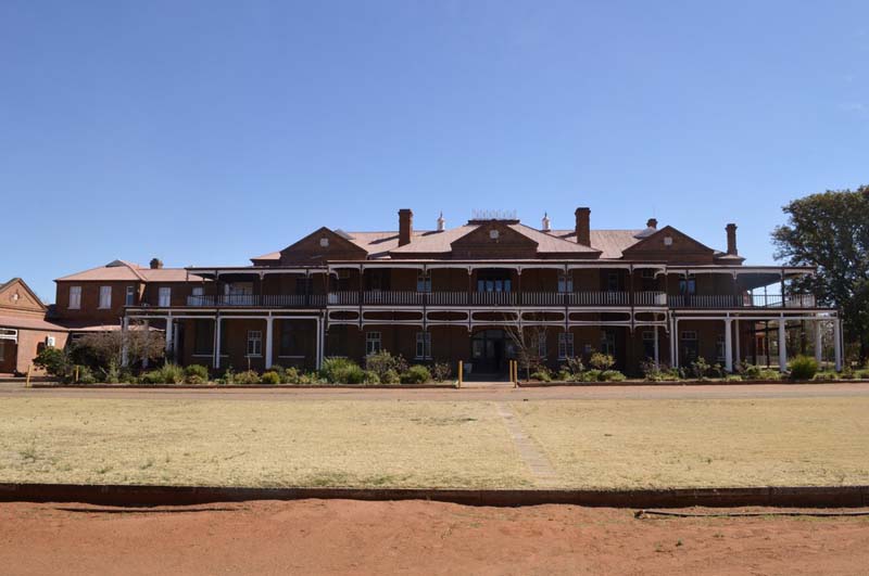 a wide building with hipped roofs and gables